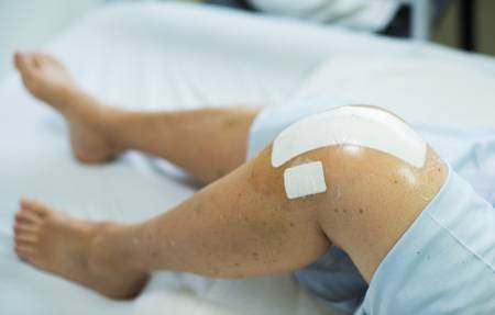 Ein Knie nach der Operation mit einem Pflasterverband